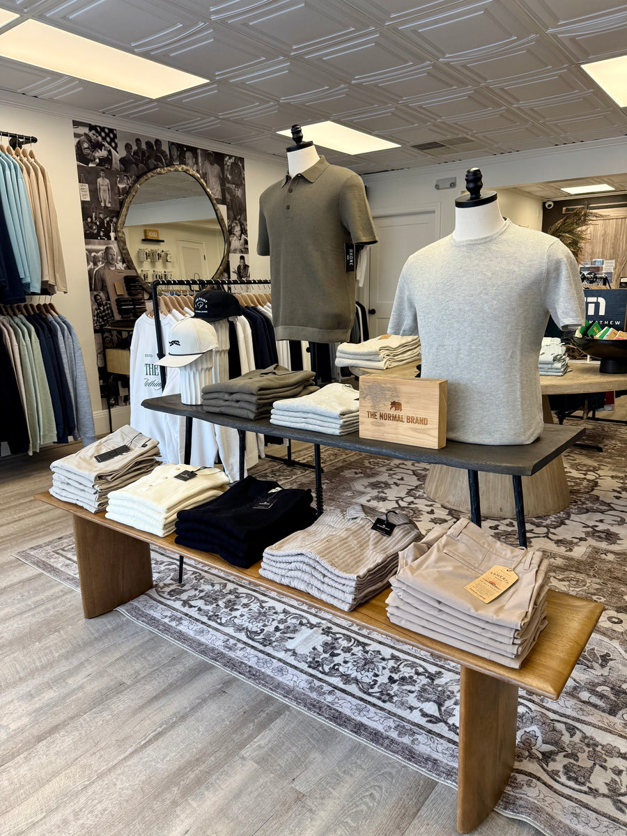 Folded and mannequin-displayed menswear at The Point Clothing Lounge in South Boston, featuring The Normal Brand