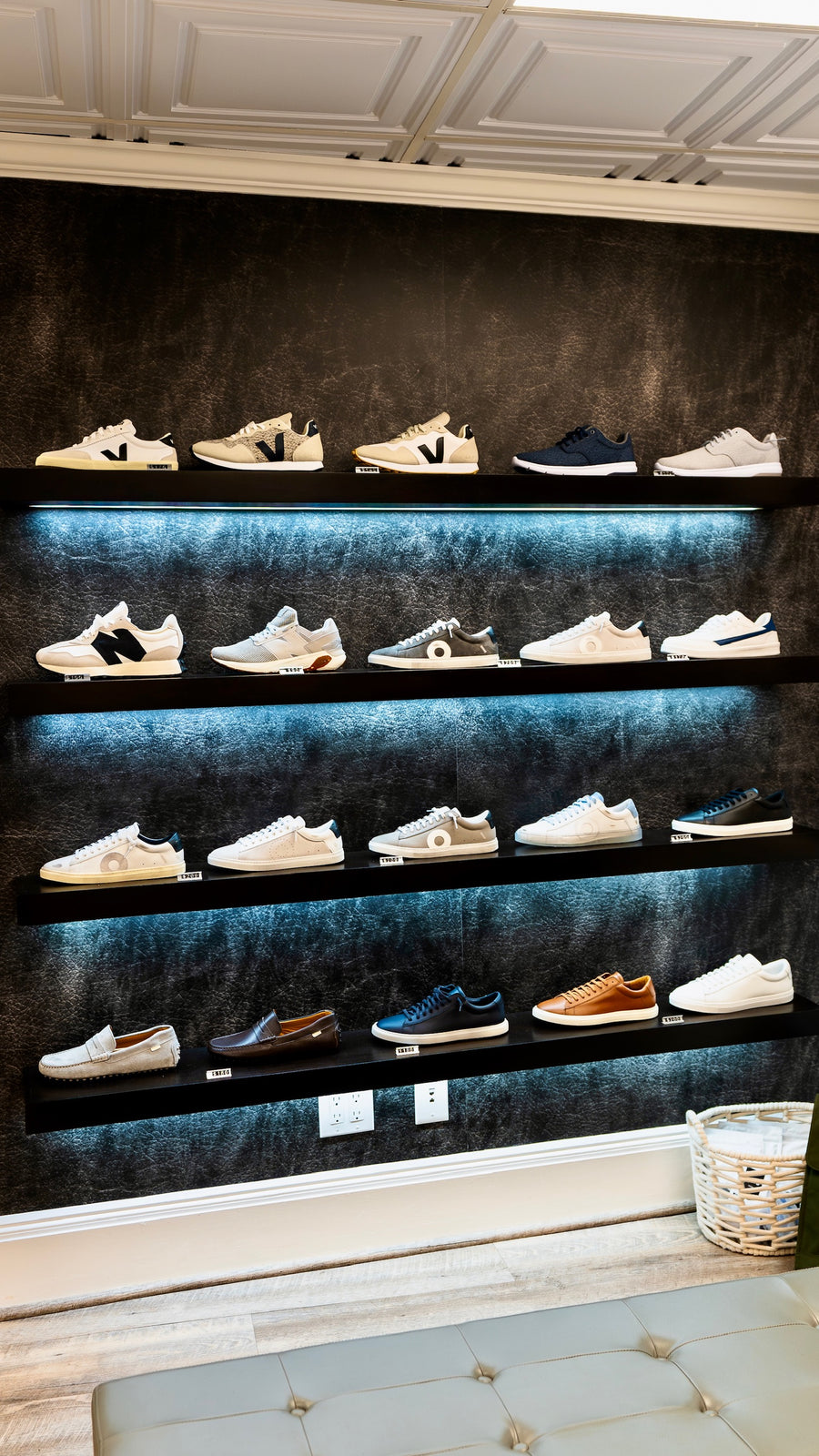 Sneaker and shoe display wall at The Point Clothing Lounge in South Boston, featuring VEJA, New Balance, and premium leather footwear